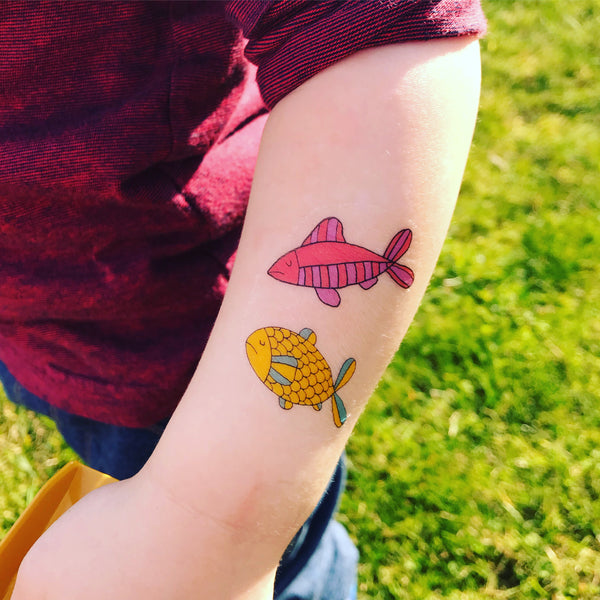 Two fish transfer tattoos on an arm