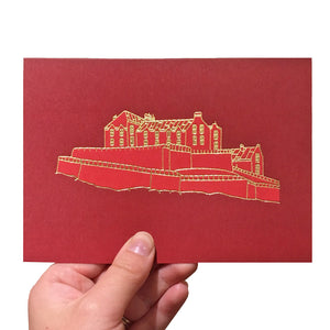 Red greeting card with a gold foiled illustration of Edinburgh Castle