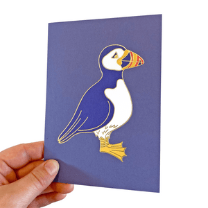 Blue card with a puffin illustration with gold foil details